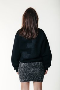 Felpa nera con grande numero 3 testurizzato sulla schiena. Abbinate a una mini gonna nera attillata e scintillante. Tessuto liscio, stile casual.