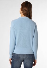 Jasnoniebieski sweter dziany o prążkowanej fakturze, z okrągłym dekoltem i długimi rękawami. Widok z tyłu ukazuje dopasowany dół, podkreślający sylwetkę.