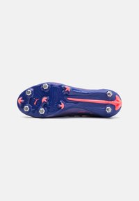 Scarpa da calcio con suola viola texturizzata, con accenti rosa e sei tacchetti in metallo per la trazione. Design aerodinamico per le prestazioni.