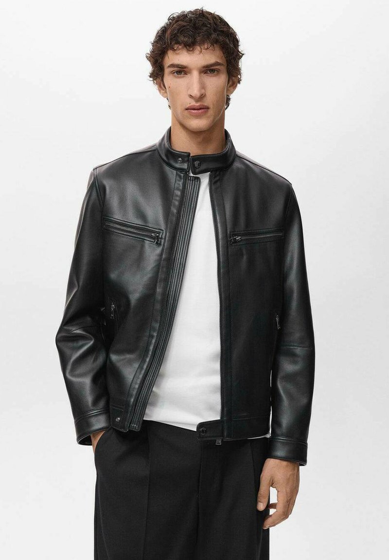 Black leather jacket with a high collar, front zip closure, and two zippered chest pockets. Smooth texture and structured design.
