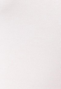 Witte ribbelstof textuur met dicht op elkaar geplaatste verticale lijnen en subtiele schaduwen die een zacht textielpatroon creëren.