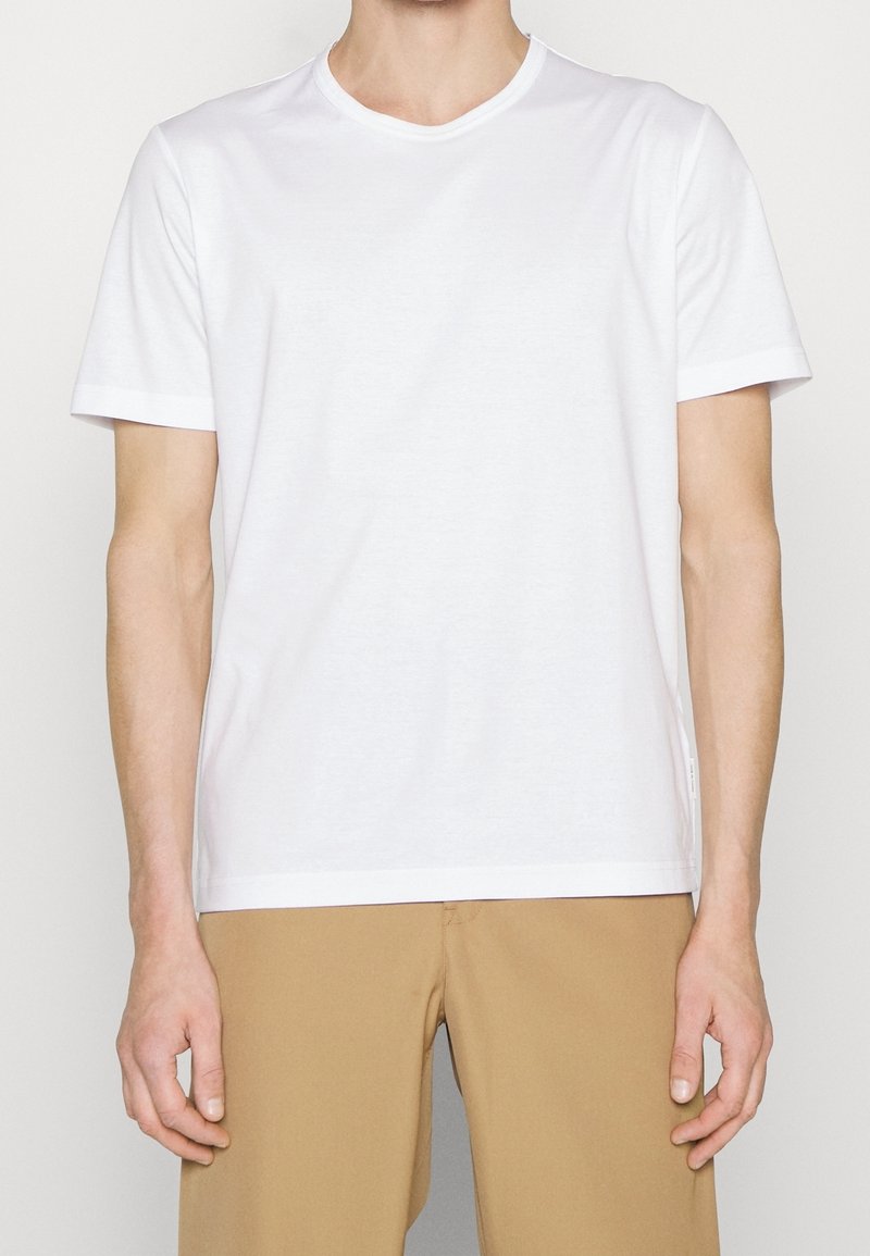 White cotton t-shirt with short sleeves, a round neckline, and a straight hem. Fabric appears soft with a smooth texture and no patterns.