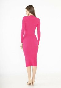 Robe midi ajustée en tissu côtelé, de couleur rose vif, à manches longues, col haut et détail de fente au dos. Assortie avec des talons hauts nude.