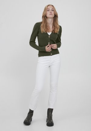 Mørkegrøn ribbet cardigan med knaplukning, parret med hvide tætsiddende jeans og sorte ankelstøvler. Simpelt design, ensartede teksturer.