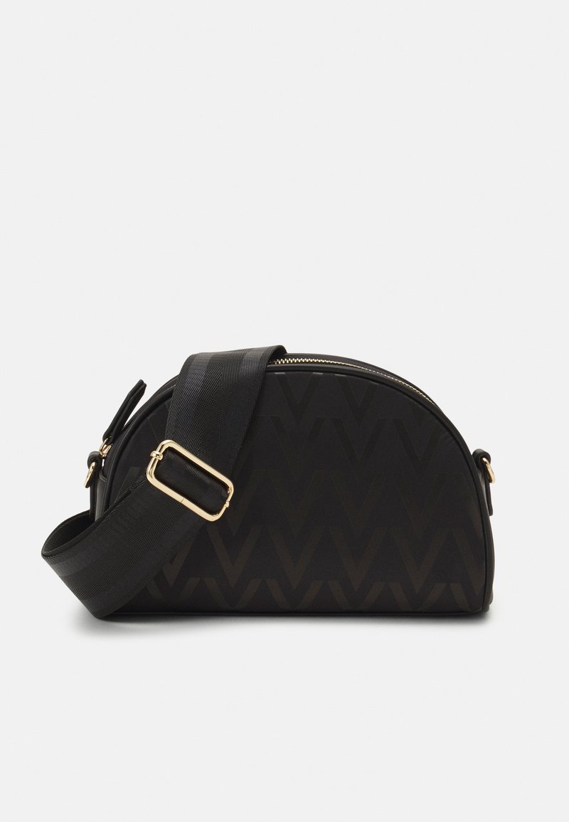 Sac noir à la forme courbée, avec un motif en zigzag, des détails dorés et une bandoulière épaisse ajustable. Texture lisse. Fermeture zippée.