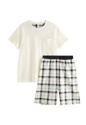 Kortærmet cremefarvet T-shirt med brystlomme kombineret med sort-hvide ternede shorts med elastisk talje.
