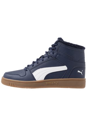 Høj top marineblå sneaker med hvid sidestribe, brun sål, snørebånd og blød pelsforing ved kraven for ekstra varme.