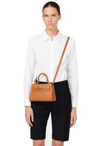 Sac à main en cuir tan avec une forme structurée, une poignée supérieure et une bandoulière amovible. Quincaillerie en ton or et finition texturée.