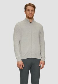 Hellgrau zip-up Sweater mit Stehkragen, gerippten Bündchen und Saum sowie glatter Textur, kombiniert mit schwarzen Hosen.