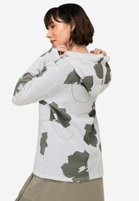 Witte hooded sweatshirt met een groene bloemenpatroon. Gestructureerde, textuurstoffering met een verlengde pasvorm en lange mouwen, voorzien van een trekkoordkap.