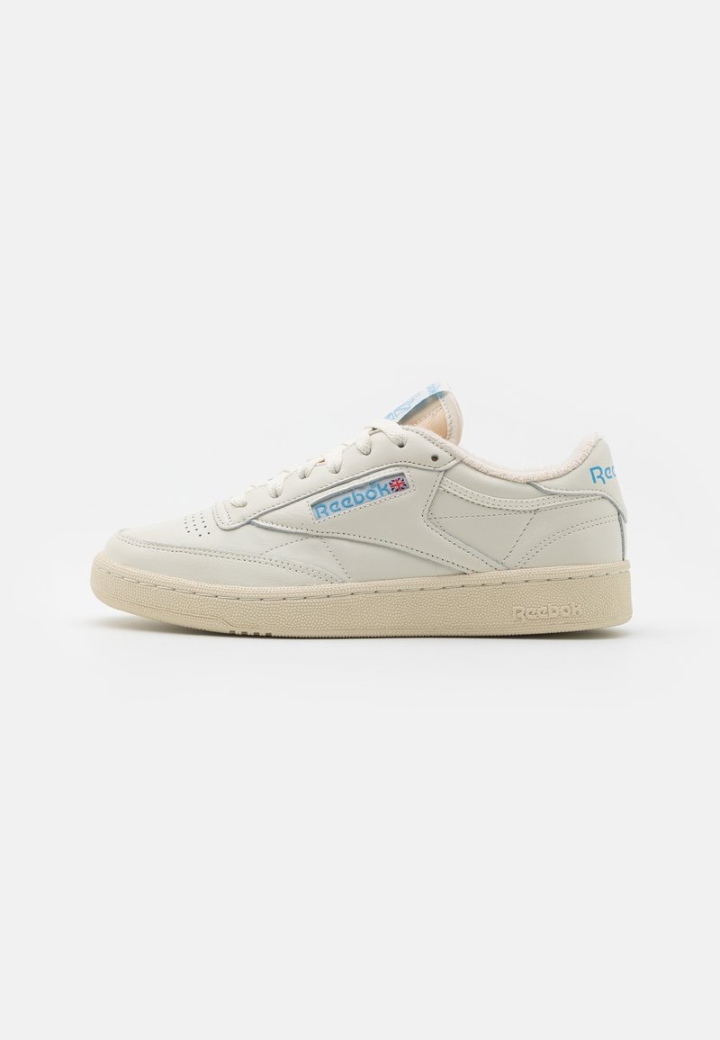 Low-top off-white leather Reebok sneaker with beige sole, light blue branding, and Union Jack detail on the side panel.