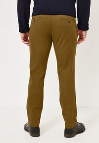Khaki trousers made of cotton, featuring a slim fit, two back pockets with buttons, and a smooth, matte texture.