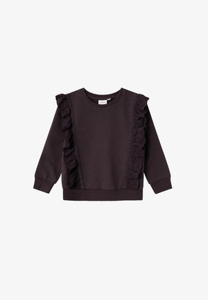 Ciemnofioletowa bluza z długim rękawem z falbanami z koronki biegnącymi pionowo wzdłuż przednich boków oraz ściągaczami na mankietach i dole.