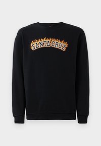 Zwarte sweatshirt met lange mouwen. Heeft de tekst "SANTA CRUZ" in vet oranje en witte letters, omringd door een vlamontwerp.