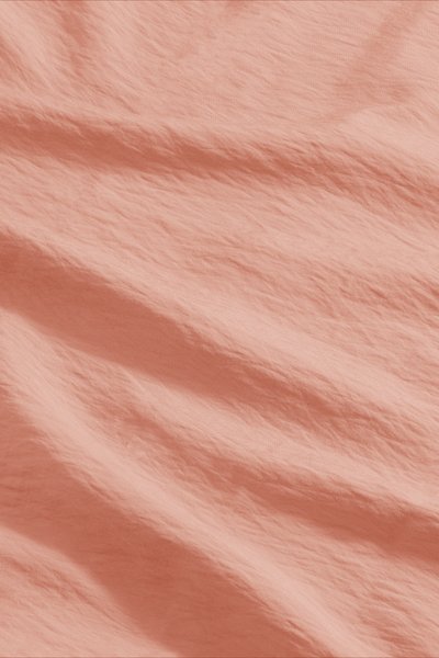 Tessuto testurizzato di colore pesca chiaro, caratterizzato da onde e pieghe delicate, realizzato in un materiale leggero con una leggera lucentezza.