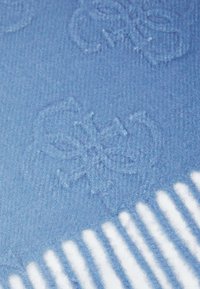 Tejido de color azul claro con una textura y un patrón floral en relieve, y bordes de rayas blancas. Material suave, con una superficie ligeramente peluda.