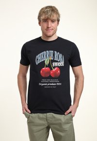 Camiseta de algodón negra con un gráfico vibrante de cerezas y texto que dice "CHERRIE ROSA sweet" con acentos en blanco y azul.