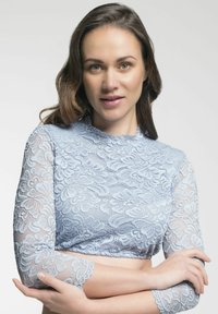 Hellblaues Spitzenoberteil mit langen Ärmeln, floralem Muster, kurzem Design, strukturiertem Finish und gewellten Kanten.