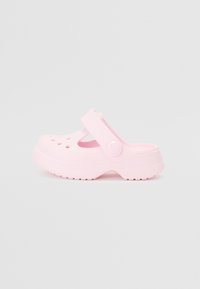 Vaaleanpunaiset saappaat, jotka on valmistettu synteettisestä materiaalista. Niissä on kantakiinnitys, ilmanvaihtoaukot ja teksturoitu pohja pitävää otetta varten.