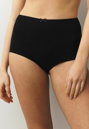 Juodos spalvos medvilninės trumpikės su aukštu liemeniu, dėvimos asmens, matomo nuo juosmens iki vidurio šlaunies, su mažu dekoratyviniu kaspinu ant liemens juostos.