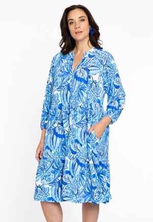 Blaues Blumenkleid mit einem gestuften Design, das über drei Viertelärmel, eine Knopfleiste und seitliche Taschen verfügt. Hergestellt aus einem leichten Stoff.