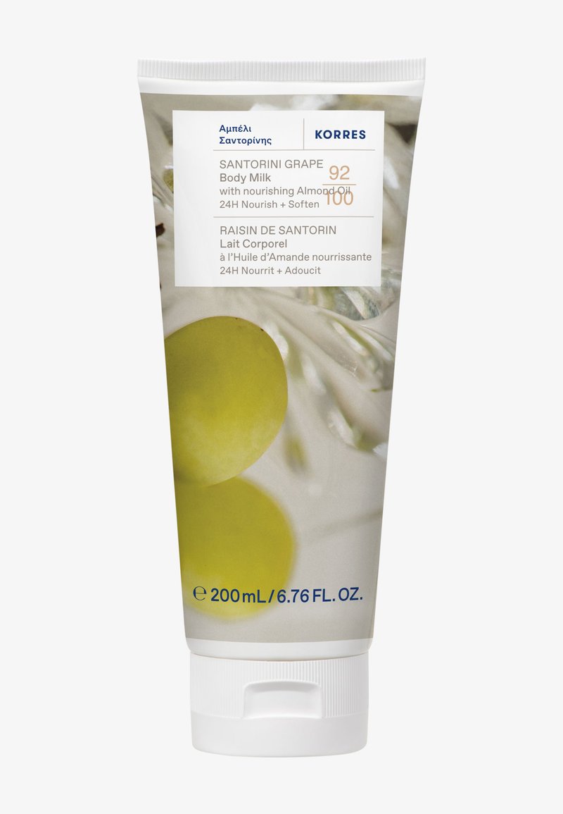 Tube blanc présentant l'étiquette de Lait Corps au Raisin de Santorin. Les éléments clés incluent des images de raisins verts et un texte bleu. Contient 200 ml.