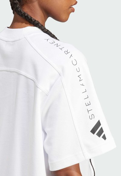 Tricou sportiv alb cu mâneci scurte, prezentând text și logo negru pe umăr. Material neted, cu o croială lejeră și guler rotund.