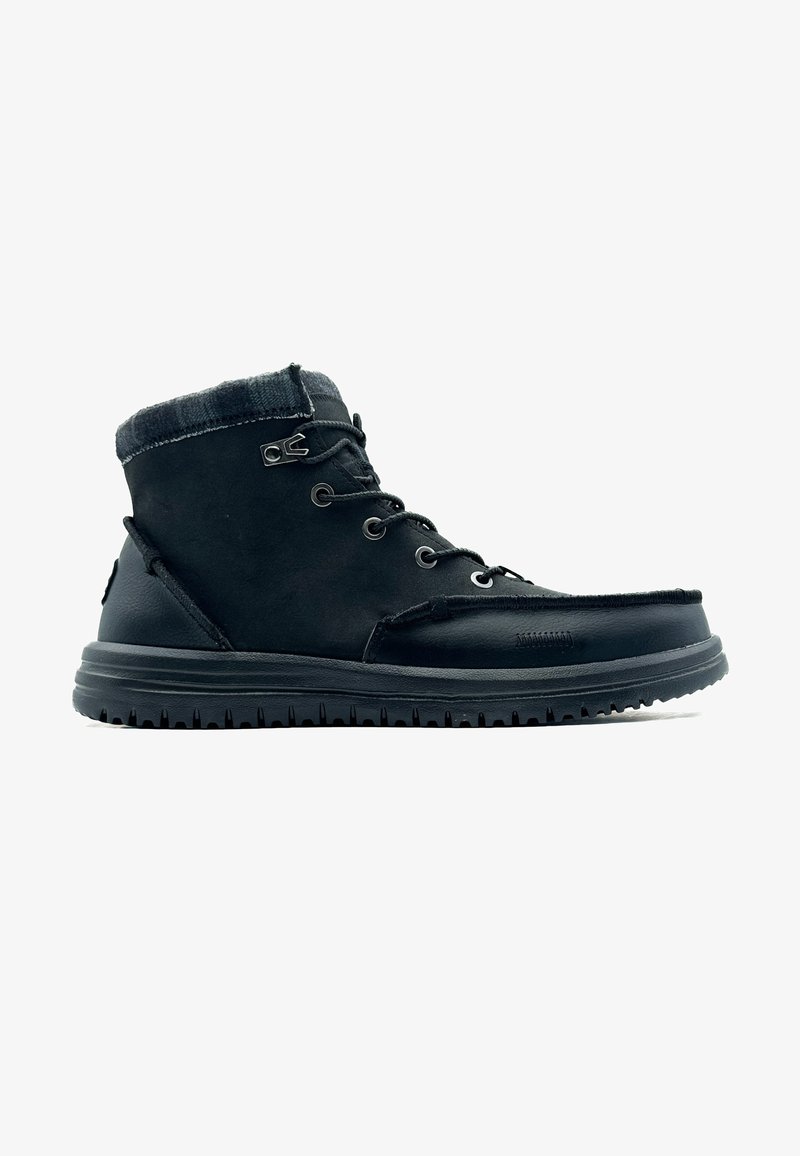 Stivale alla caviglia in pelle nera con tomaia in suede testurizzato, design con lacci e suola in gomma con un motivo scanalato per una maggiore aderenza.