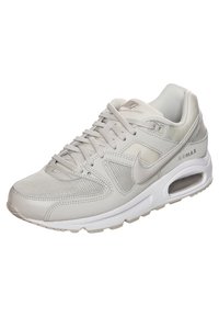 Light gray Nike Air Max sneaker featuring a mix of mesh and smooth leather. Cushioned sole with visible air unit, round laces, and logo accents.