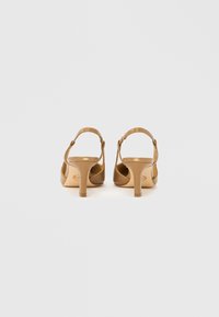 Beżowe sandały na wysokim obcasie z cienkimi paskami, gładkim wykończeniem, regulowanym paskiem wokół kostki oraz smukłym obcasem, wyposażone w wyściełaną wkładkę.