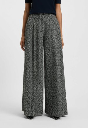 Pantaloni a gamba larga in un motivo houndstooth bianco e nero, con vita alta, tessuto morbido e silhouette fluida.