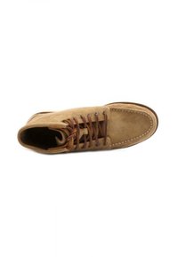 Stivale alla caviglia in suede marrone con punta arrotondata, lacci marroni e cuciture a contrasto. Texture morbida con un design minimalista e senza branding visibile.