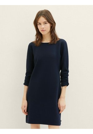 Robe bleu marine à manches longues en tissu texturé et côtelé. Présente un col rond et une coupe droite, atteignant le mi-cuisse.