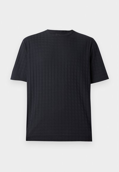 Melnā īsās piedurknes T-kreklā ir teksturēts režģa raksts, apaļa kakla izgriezums un brīvs piegriezums. Izgatavots no mīkstas, vieglas auduma.