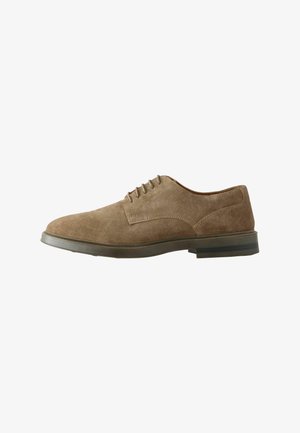 Chaussures à lacets en daim marron avec un bout arrondi, une surface texturée et une semelle en caoutchouc grise robuste, comportant cinq œillets et un design minimaliste.