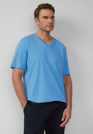 Jasnoniebieska koszulka V-neck z krótkimi rękawami, wykonana z miękkiej tkaniny. Posiada delikatne logo na piersi oraz luźny krój.