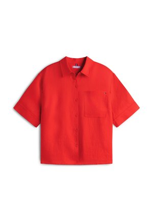 Chemise rouge à manches courtes en tissu léger. Dispose d'une fermeture à boutons sur le devant et d'une poche poitrine unique. Design épuré et simple avec une couleur unie.