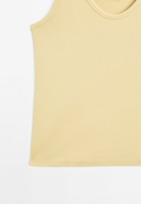Gul ribbet crop top med rund halsudskæring og syede kanter, som har en glat tekstur og et minimalistisk design.
