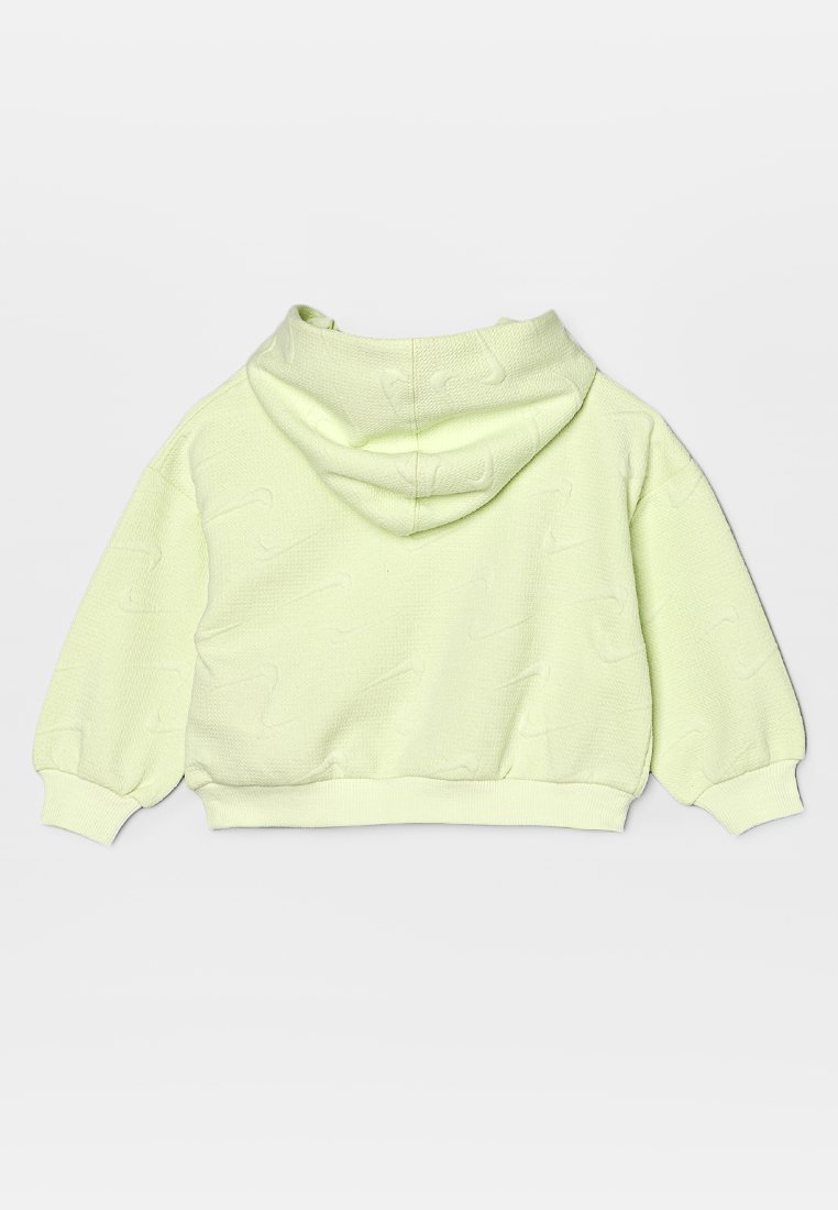 Haut de hoodie court vert clair avec un tissu texturé, des manches surdimensionnées et une grande capuche. Présente un motif de logo discret sur l'ensemble.