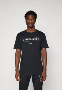 Sort bomulds t-shirt med "SPURS" i hvid tekst og Nike-logo. Korte ærmer, rund hals, standard pasform, glat tekstur.