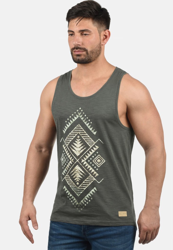 Mørkegrøn tanktop lavet af stof med en blød tekstur, der har et centralt tribal geometrisk print i guld- og cremefarver.