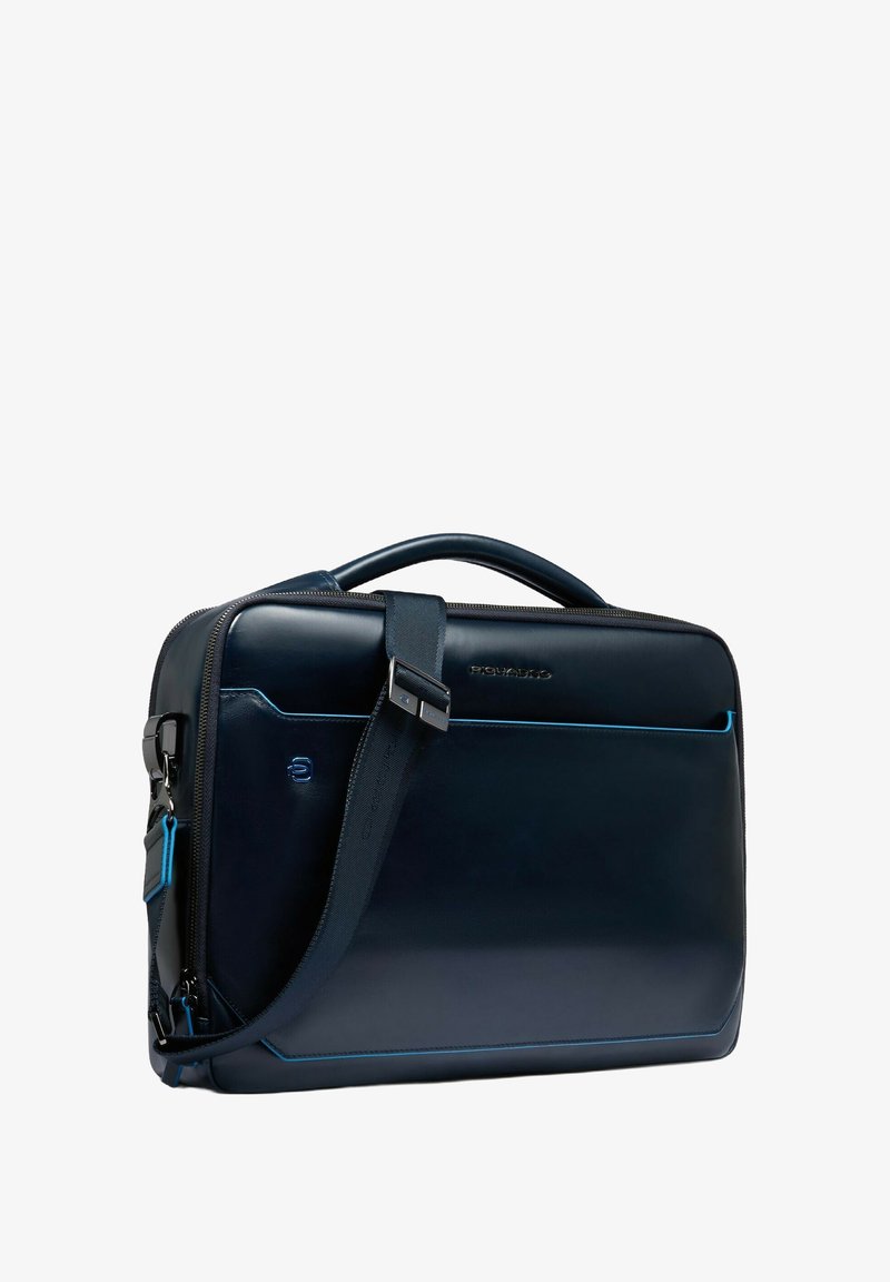 Borsa a tracolla in pelle blu scuro con una texture liscia, dotata di una tracolla removibile e cuciture blu a contrasto.