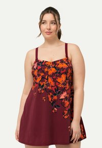 Bordeaux zomerjurk met een bloemenpatroon in oranje en zwart, voorzien van dunne schouderbandjes en een losse A-lijn pasvorm. Glad stoftextuur.