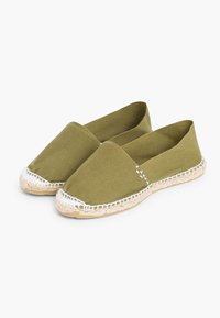 Espadrilles en toile vert olive avec une semelle en jute tressé et une couture blanche le long du bord, dotées d'un design à enfiler et d'un bout arrondi.