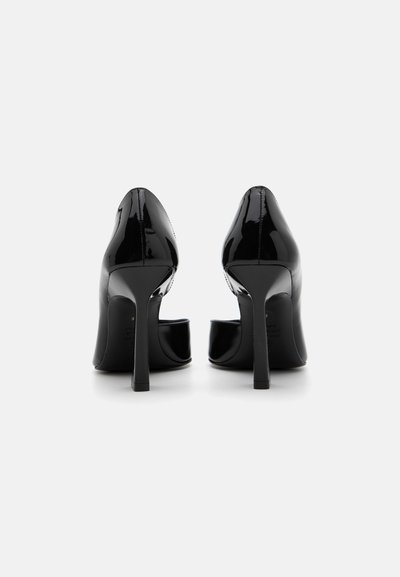 Chaussures à talons hauts en cuir verni noir avec des orteils ronds, un design découpé à l'avant et des talons aiguilles fins.