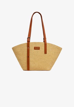 Kootud õlgkott pruunide nahkidega. Omaduseks on avar, kitsenev kuju ja logo patch ees. Tekstuuriga pind.