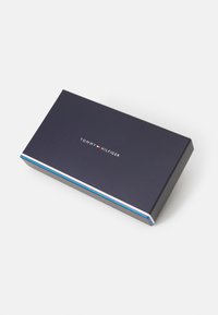 Tommy Hilfiger rektangulær gaveeske, marineblå papp med en hvit, rød og blå stripe langs kanten, med logoen sentrert på toppen.