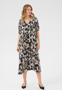 Leopard-print dress in lightweight fabric, featuring a V-neck, short puff sleeves, and a flowy, mid-length silhouette.