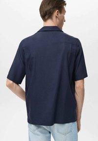Korte mouwen overhemd van marineblauwe stof, met een ingesneden kraag, een ontspannen pasvorm en een rugnaad. Glad textuur, casual ontwerp.