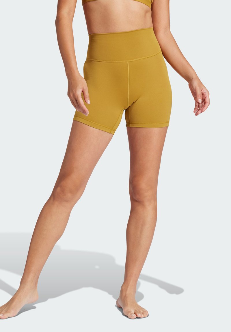 Mosterdgele hoge taille shorts met een gladde textuur, voorzien van een aansluitende pasvorm en platte naden. Geen zichtbare patronen of metalen onderdelen.